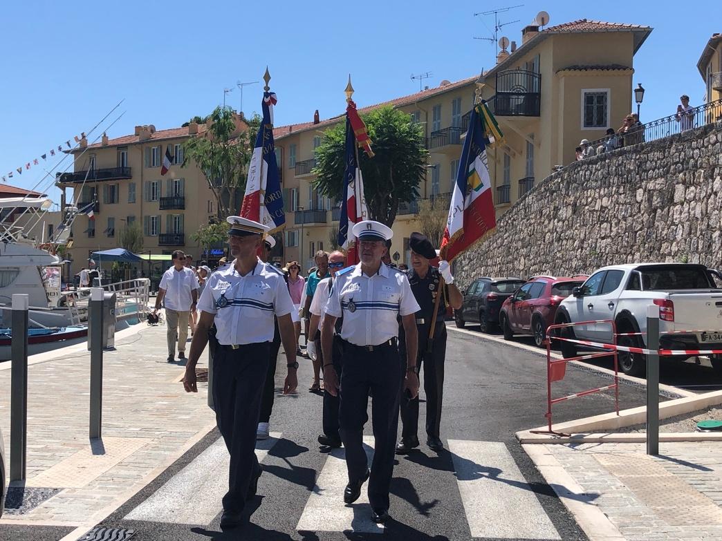 A group of people in uniform walking on a street

Description automatically generated
