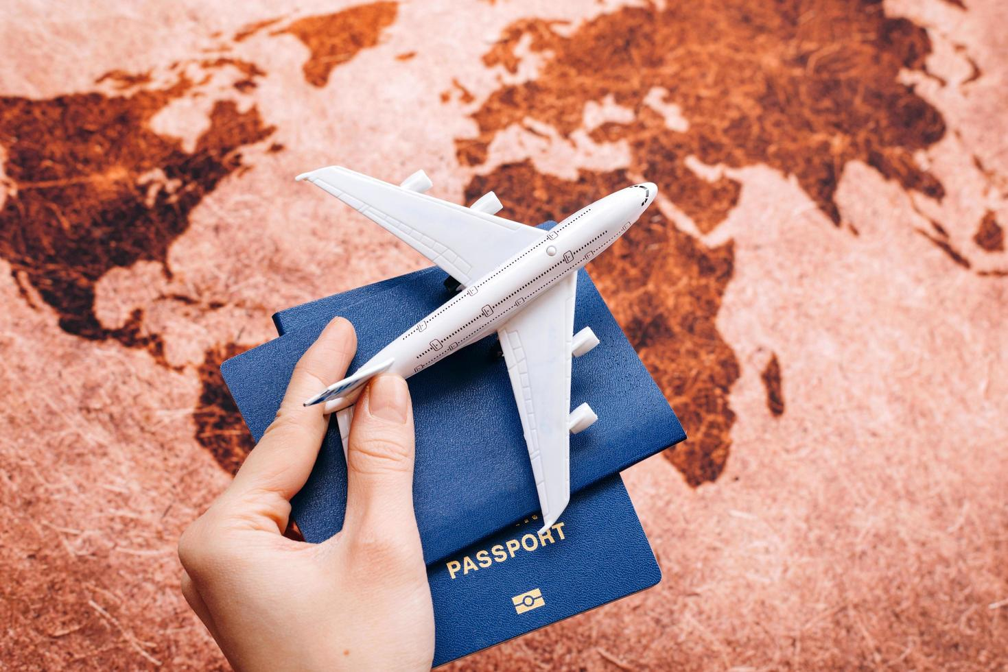 Passport on the leather world map and model airplane