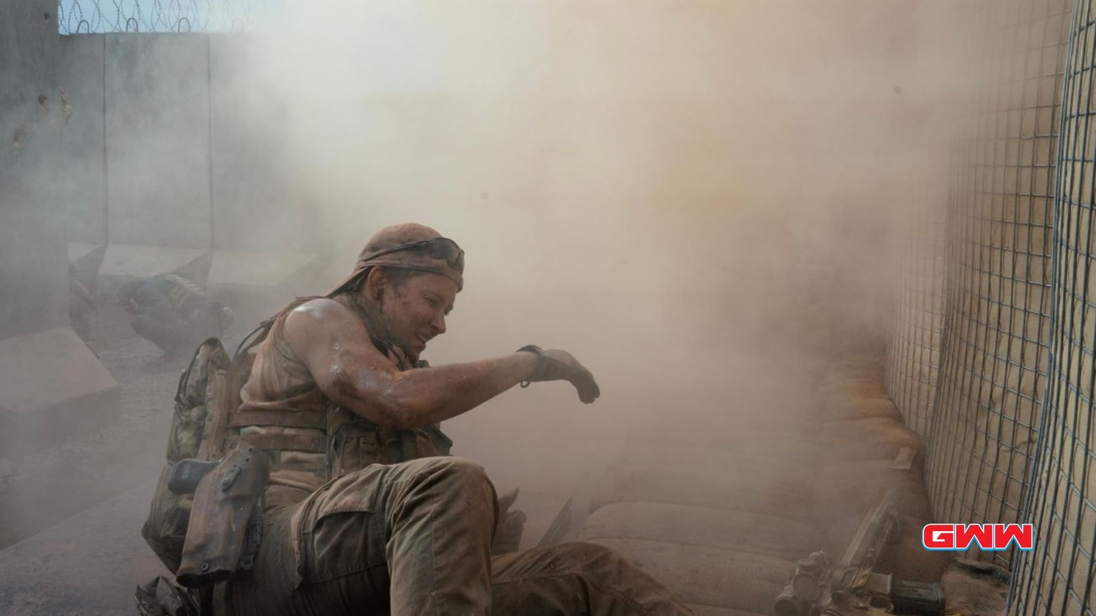 Jill Wagner as Bobby covered in dust, crouching down during an intense battle scene.