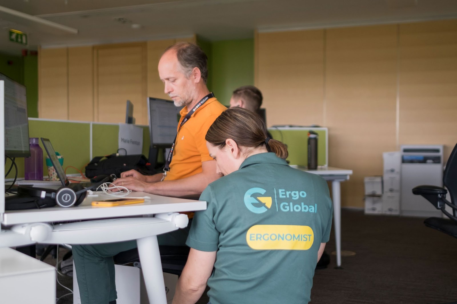 An ergonomics consultant providing expert advice to an employee at her workstation.