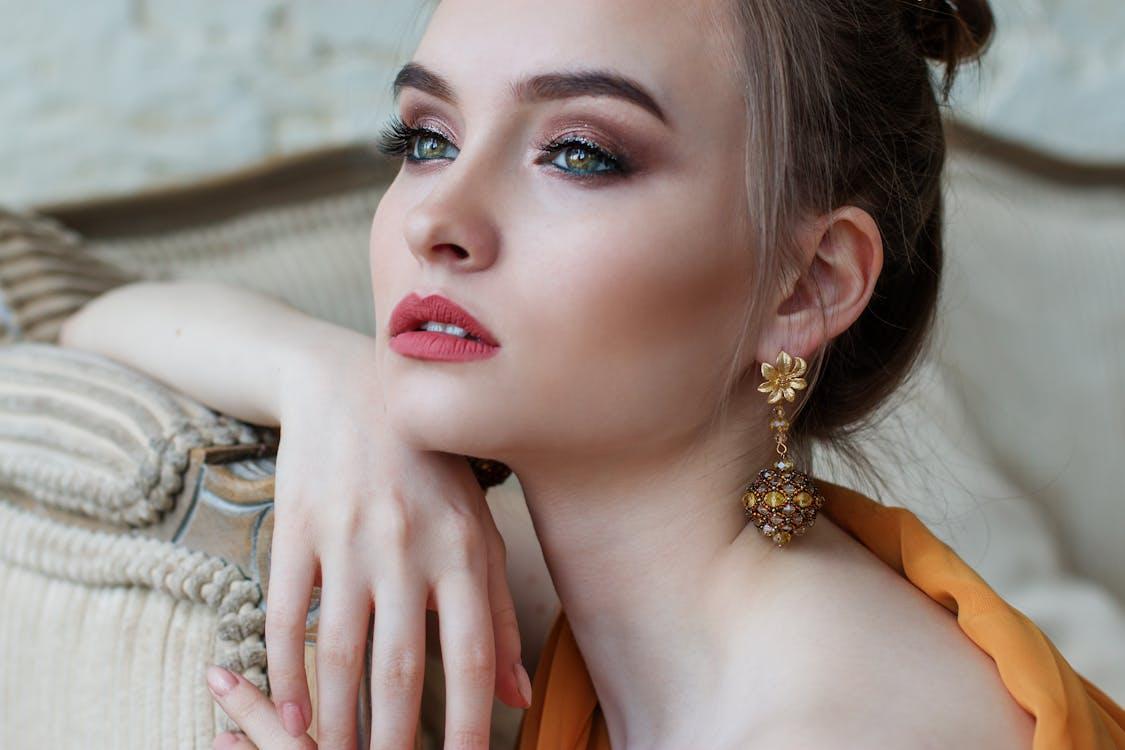 Free Stunning close-up portrait of a woman with elegant makeup and jewelry, epitomizing modern fashion and beauty. Stock Photo