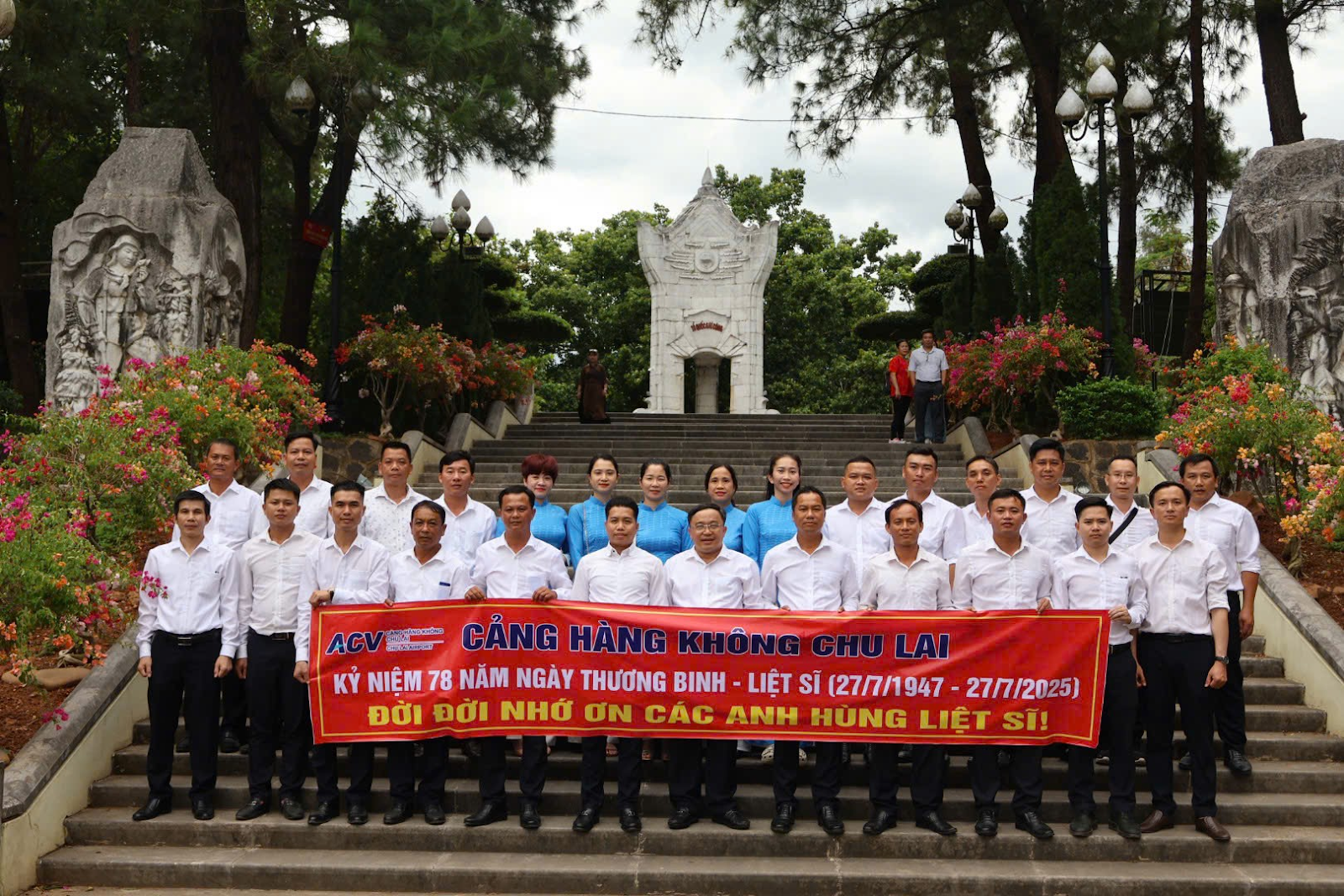 A group of people standing on steps holding a bannerAI-generated content may be incorrect.