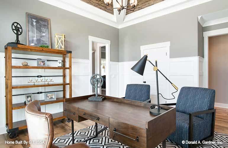Study with a wooden shelving unit and a wooden desk complemented with upholstered chairs.