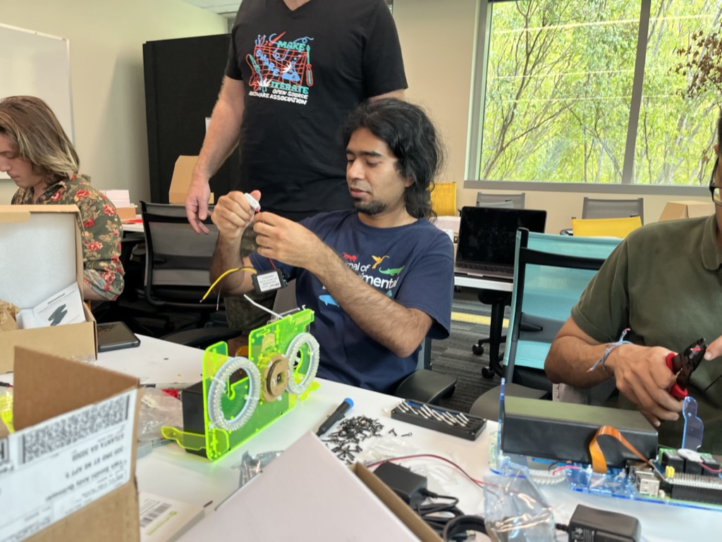 Photo of a workshop attendee attaching wires from the 12V regulator to a lever nut. 