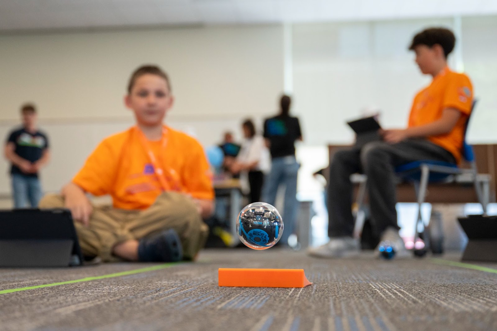 Blurred image of student playing with a sphere robot in focus