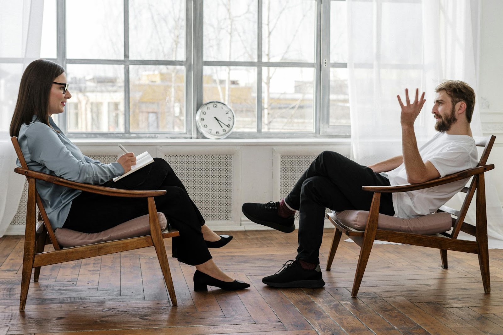 https://www.pexels.com/photo/person-in-black-pants-and-black-shoes-sitting-on-brown-wooden-chair-4101143/
