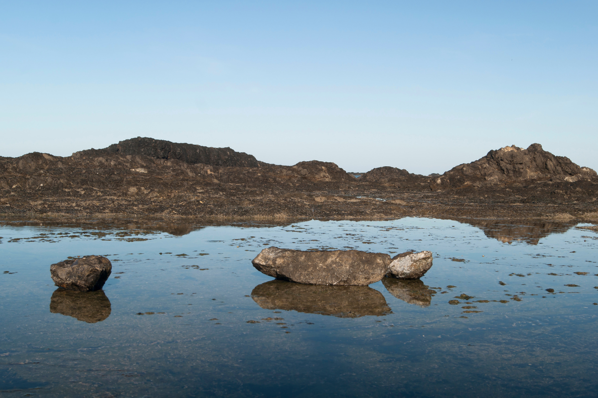 There are three stones in the clean and clear water and 