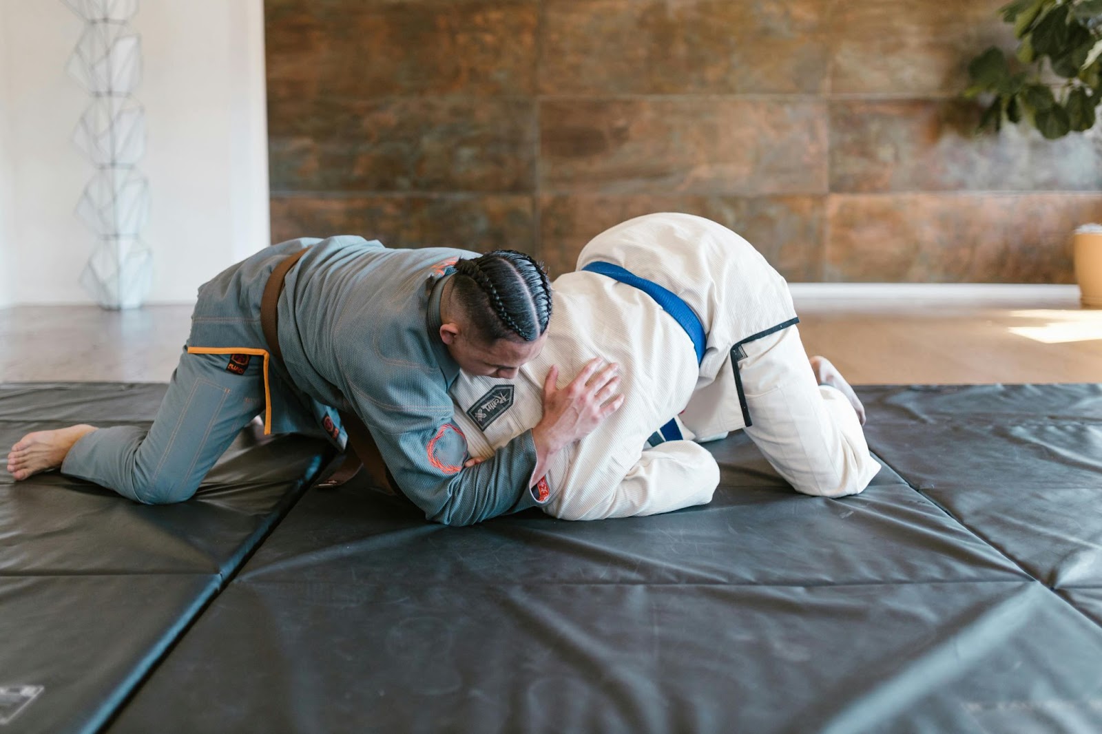 A martial arts student and instructor grappling on the ground