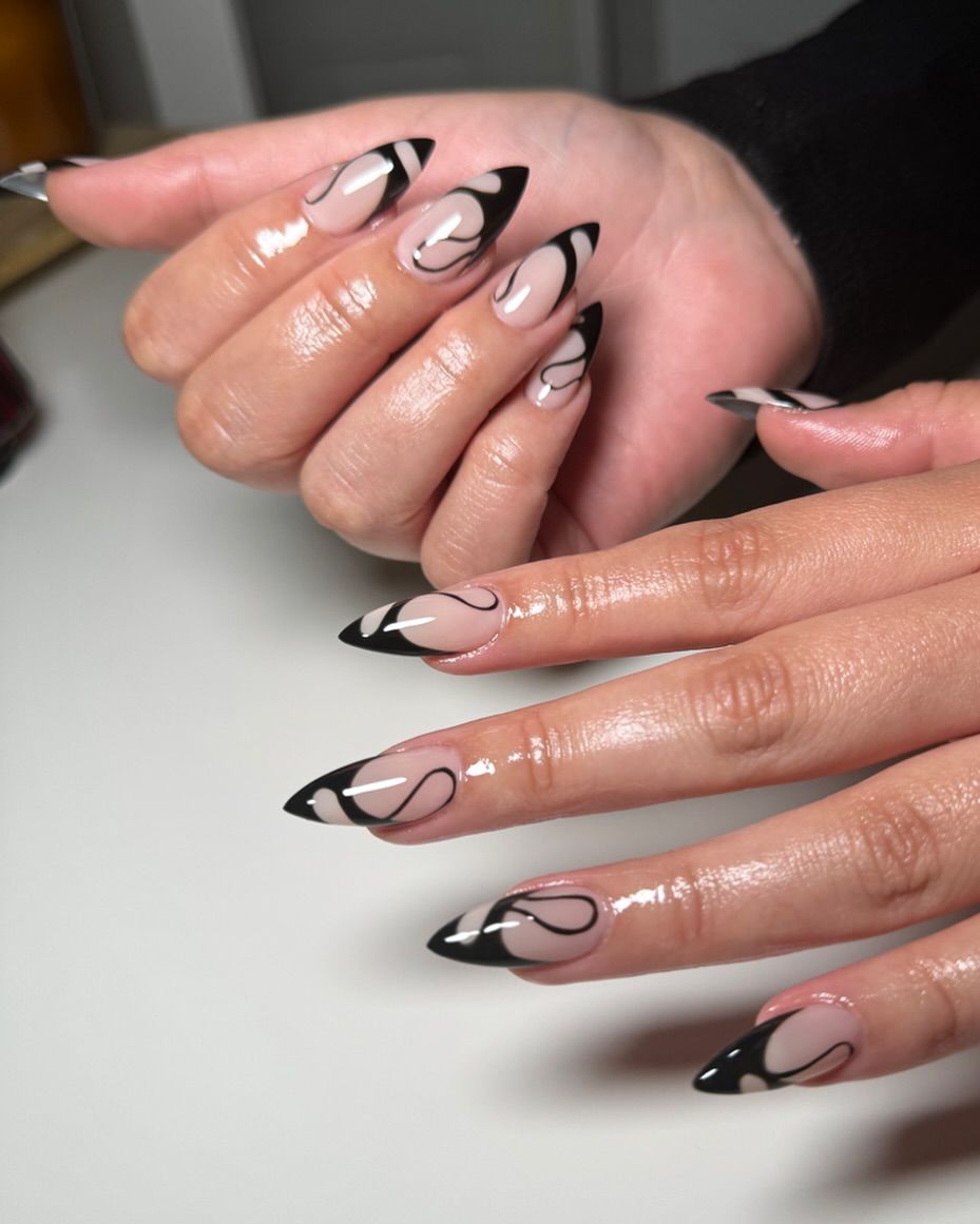 Close-up of a person's hands with black nails having Swirly Black Lines on Nude Base