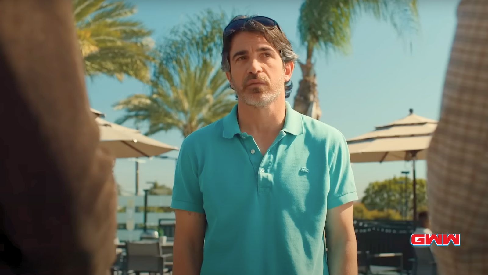 Chris Messina as Nathan Bartlett, standing outdoors in a blue polo shirt.