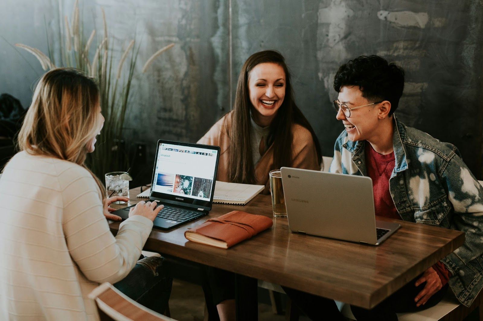 Three colleagues sharing a laugh while working together