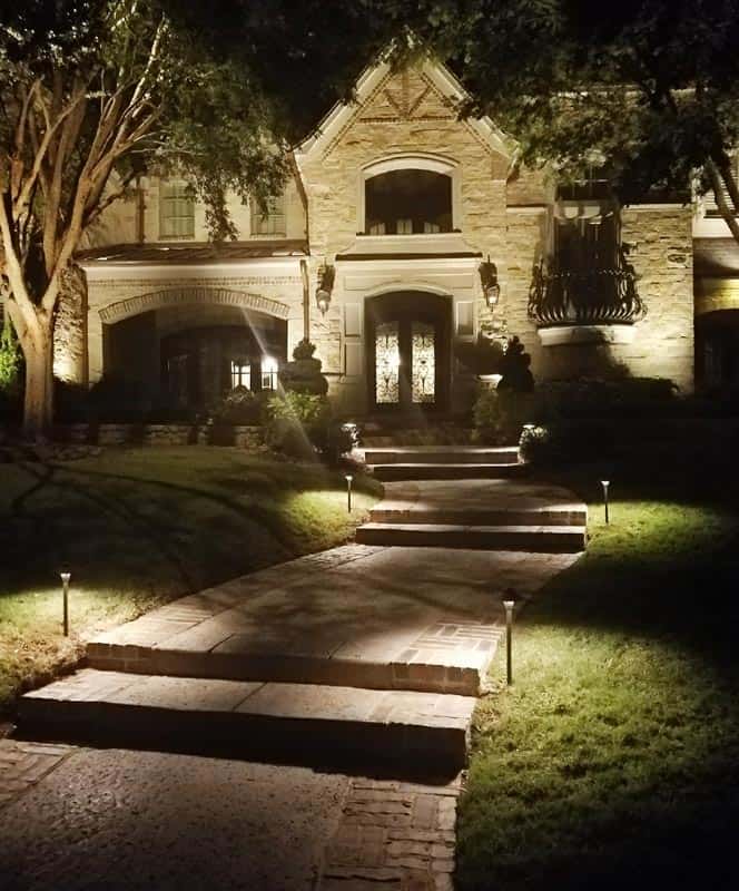 Path lights illuminating a walkway to a house.