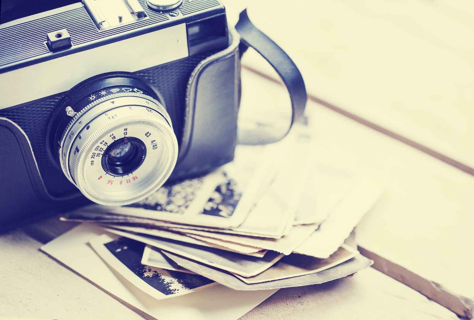 (A vintage camera rests on top of a stack of throwback photos, capturing the essence of bygone days.)