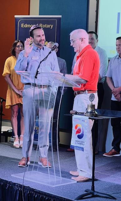 A person standing at a podium with a microphoneDescription automatically generated