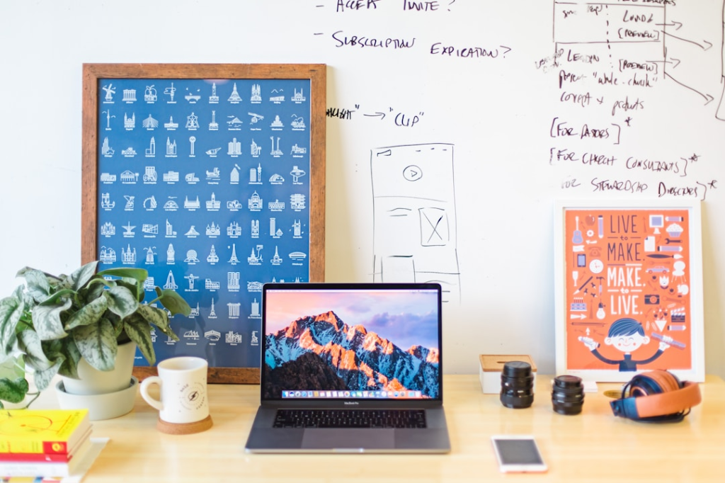 MacBook Pro on brown wooden table beside white mug by Mia Baker