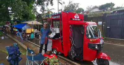 A person standing next to a red food truck

Description automatically generated