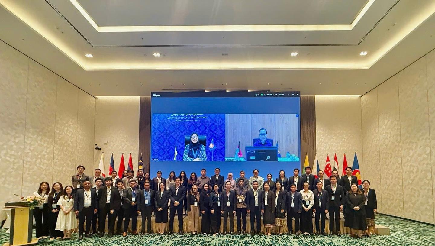 A group of people standing in front of a large screen

Description automatically generated