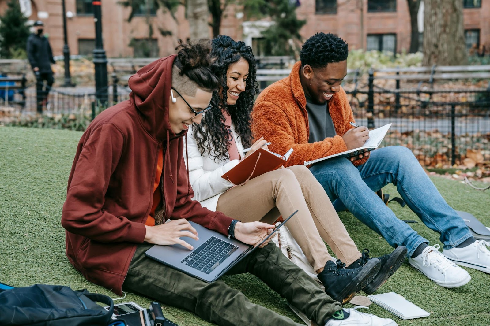 3 college students having fun studying in a park