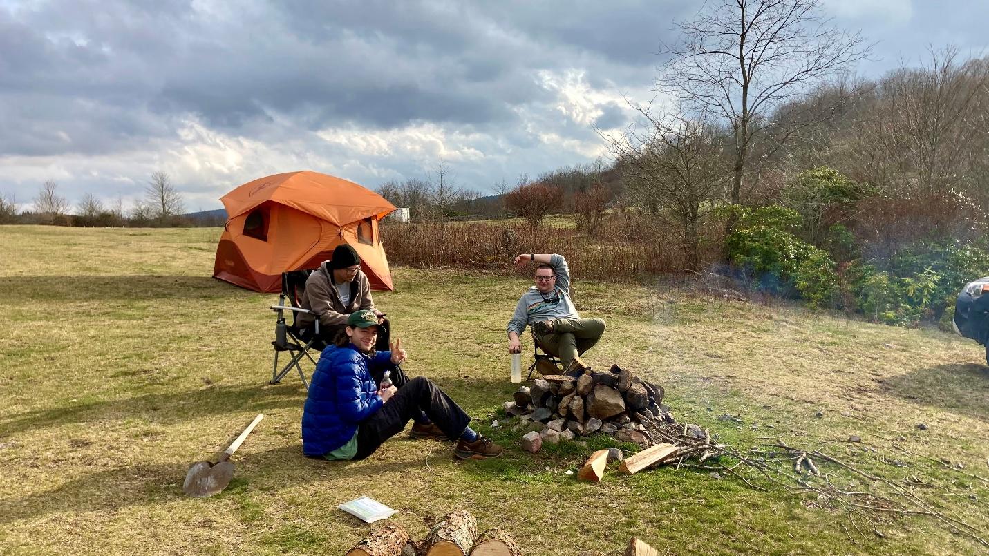 A group of people sitting around a campfire

AI-generated content may be incorrect.