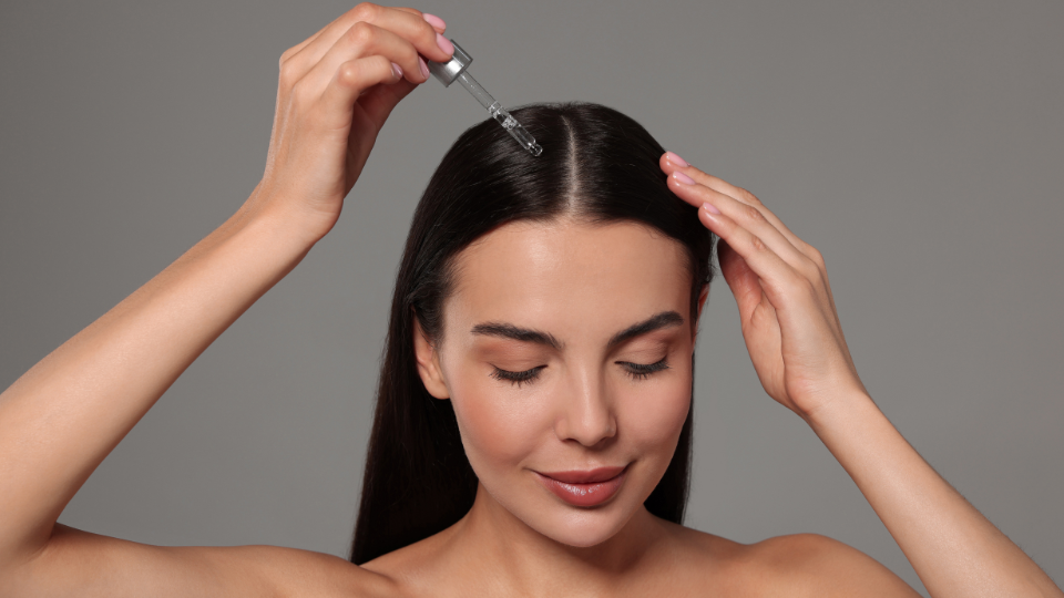 Woman using a hair serum.