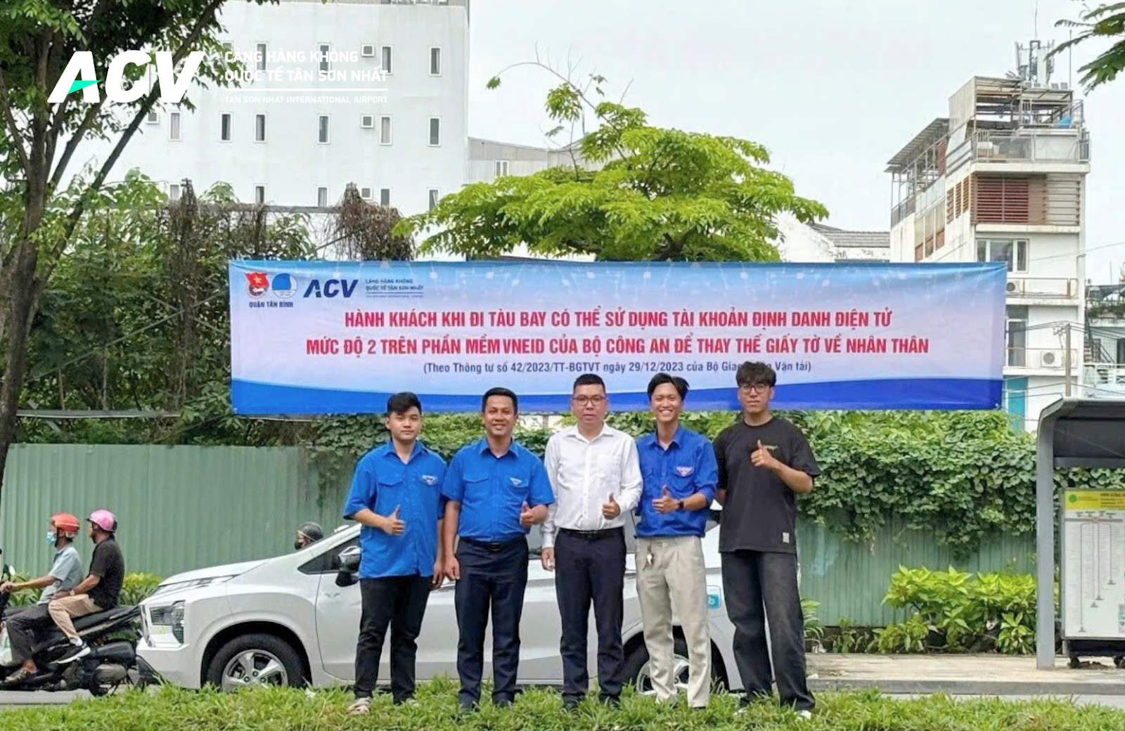 A group of men standing in front of a bannerDescription automatically generated