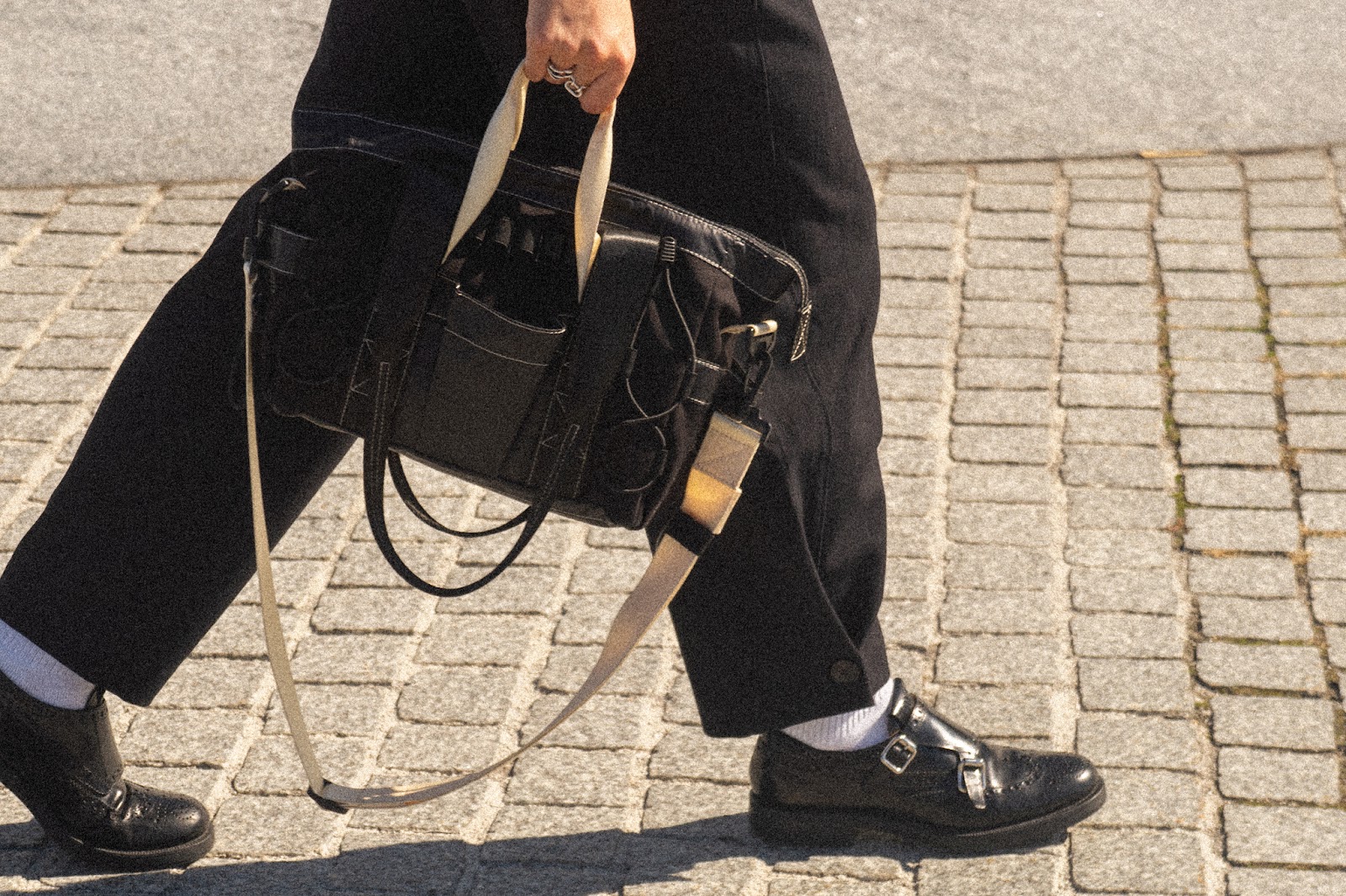 Person carrying the smaller FHD Utility Tote featuring the adjustable crossbody strap. 