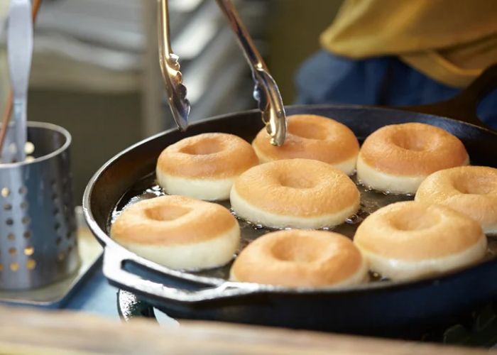 Plain doughnuts being fried at Higuma Doughnuts