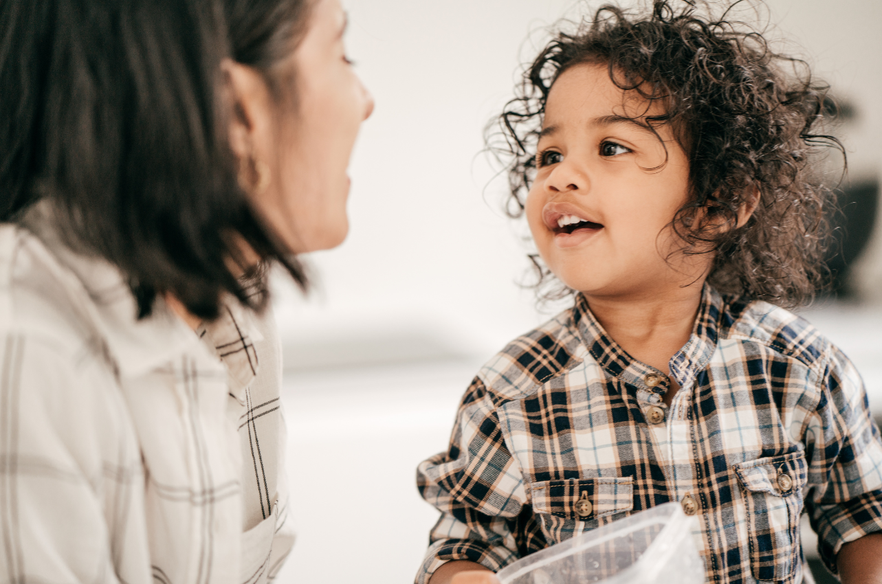 Mom talking to toddler with curly black hair // Healthier Baby Today