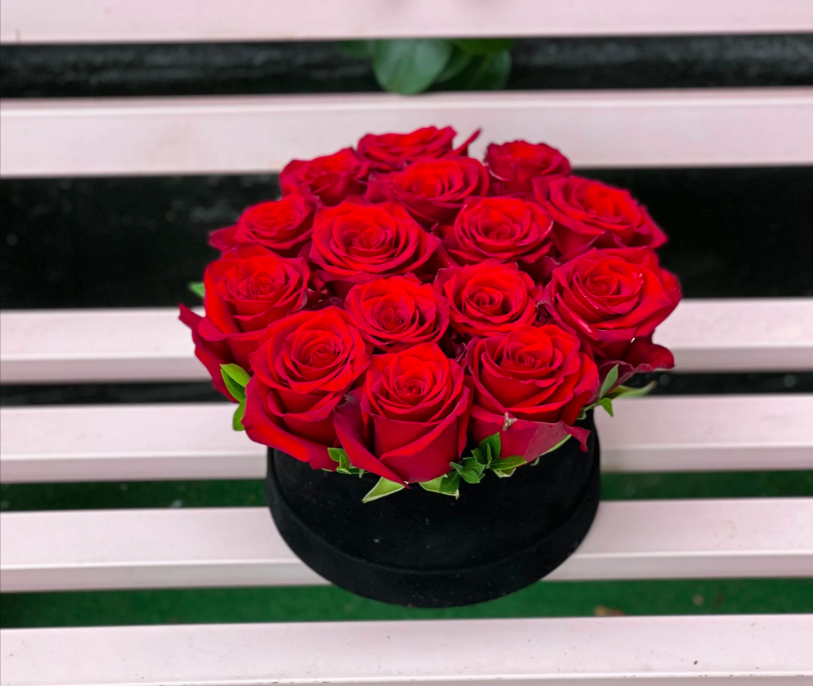 An elegant box filled with 12 to 15 lush red roses, showcasing their rich color and beauty, perfect for expressing love and admiration.