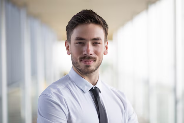 A man in white shirt smiling for a professional headshot