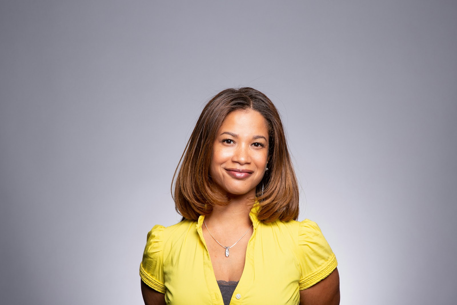 Medium skin tones complement yellows: A woman posing for a headshot