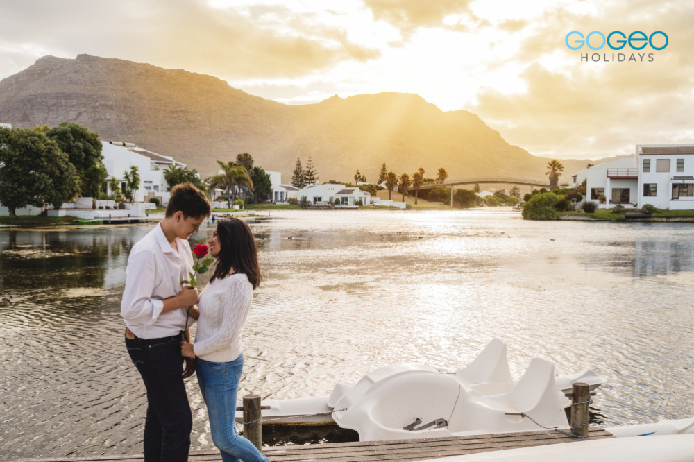 A married couple standing beside a river