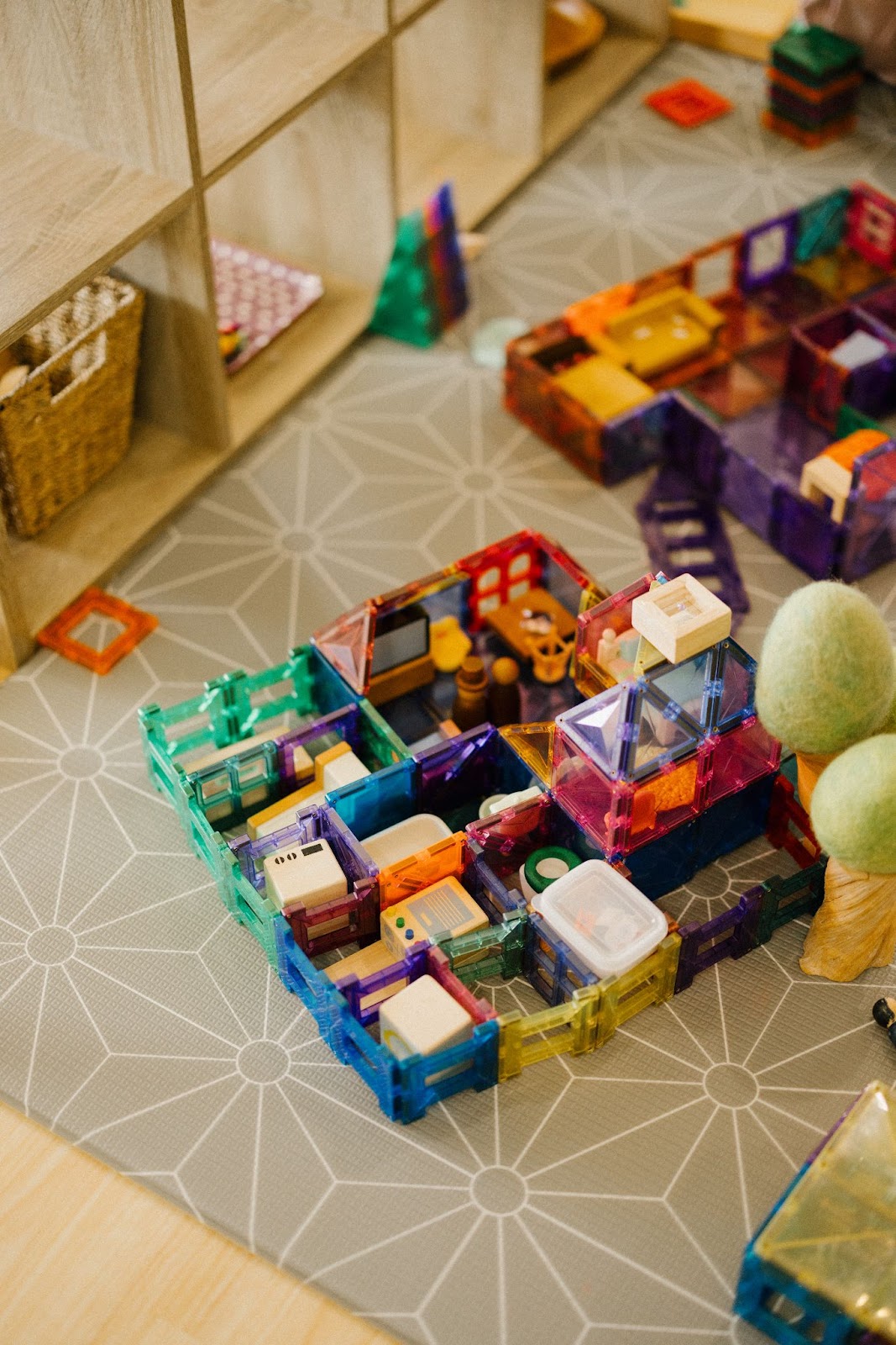 A child's imaginative play scene features a colourful house filled with a family inside, showcasing detailed furniture and household items. The scene includes miniature representations of a living room, kitchen, and bedroom, reflecting the child's creativity and storytelling as they bring their play to life.
