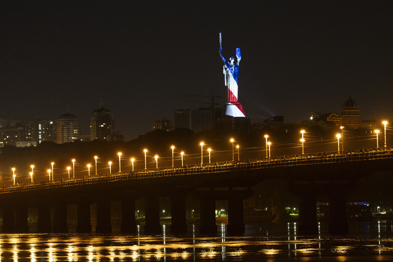 The Ukrainian Motherland monument is illuminated in the colors of an American flag.