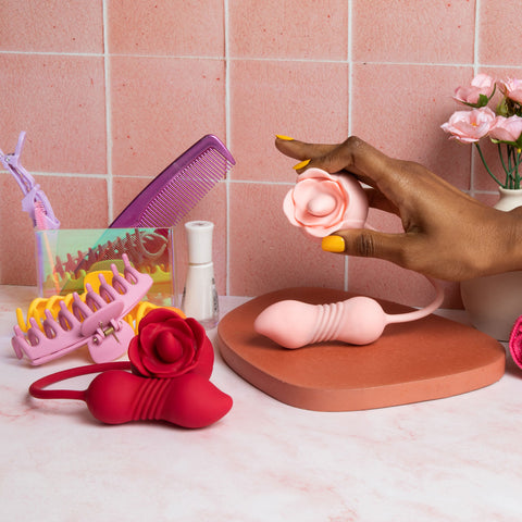 a hand holding a pika flora vibe pro next to a vanity table