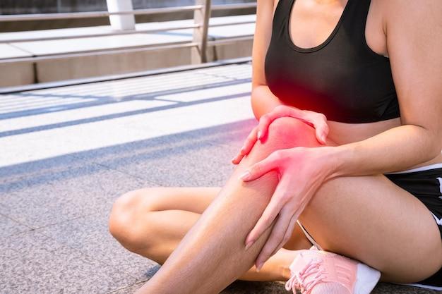 Young sport woman suffered from knee pain injury while running in city