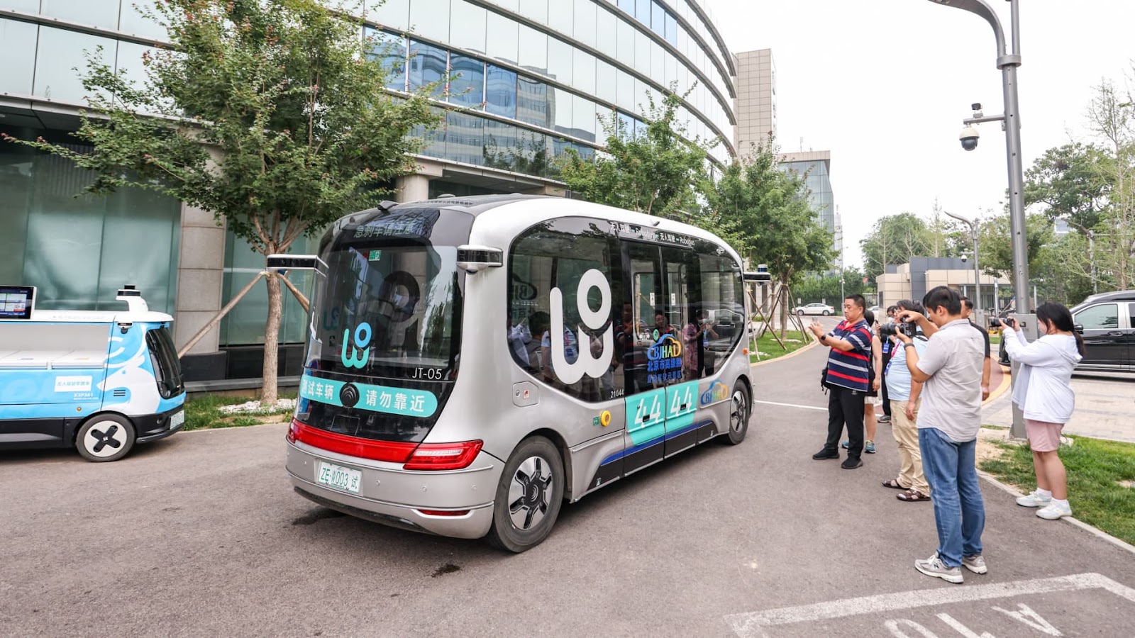 BEIJING, CHINA - JULY 11: People take photos of WeRide Robobus, a fully-driverless shuttle capable of SAE Level 4 autonomous driving, at Beijing High-level Autonomous Driving Demonstration Area on July 11, 2024 in Beijing, China. (Photo by Jia Tianyong/China News Service/VCG via Getty Images)