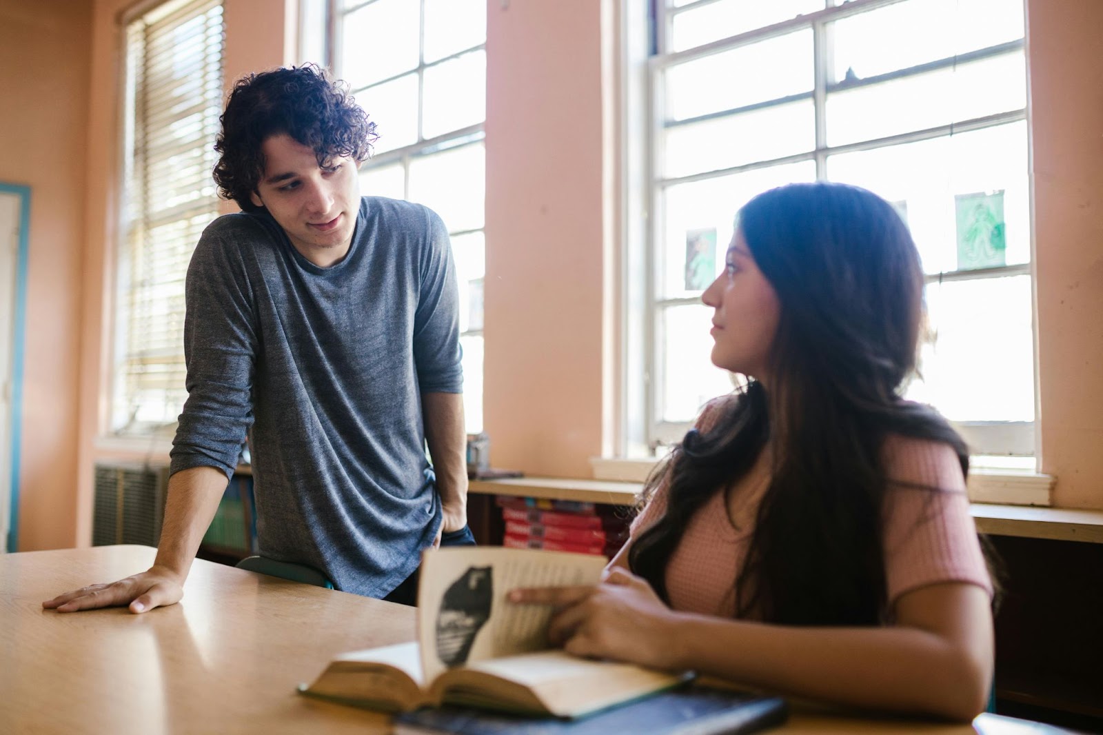 Two college students having a chat in class