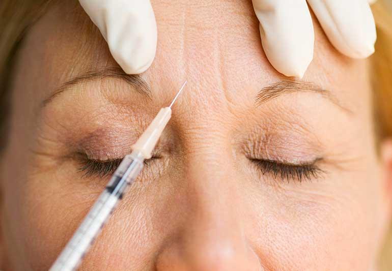 A person getting botox injection on their forehead

Description automatically generated