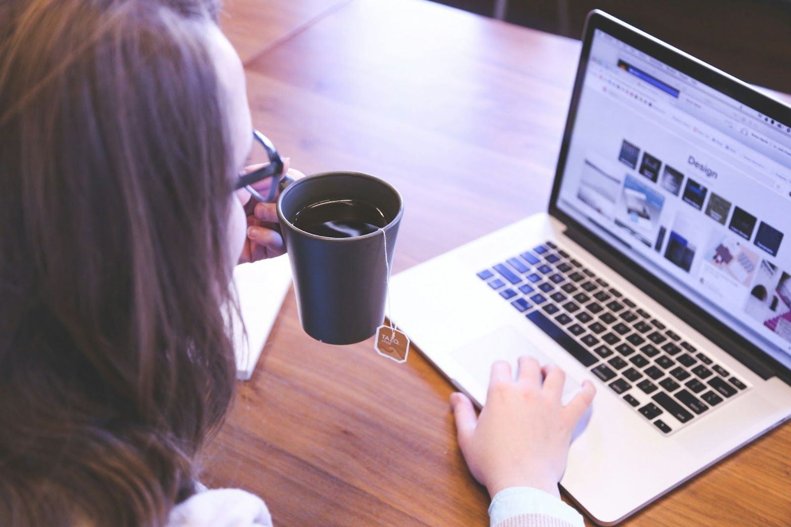 Woman having tea while working on her laptop