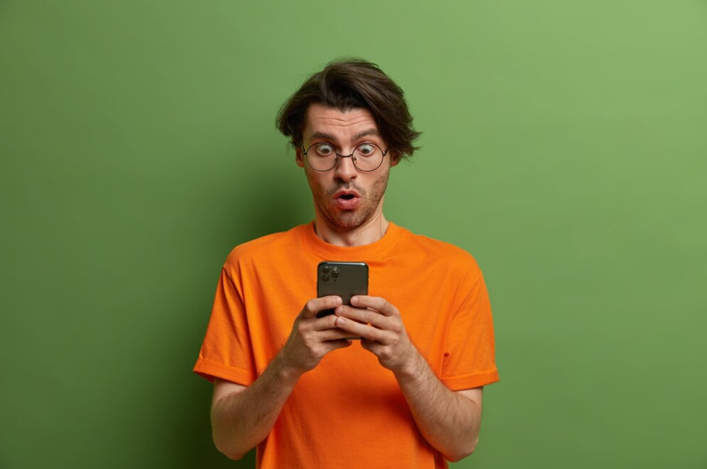 A surprised person looking at their smartphone 