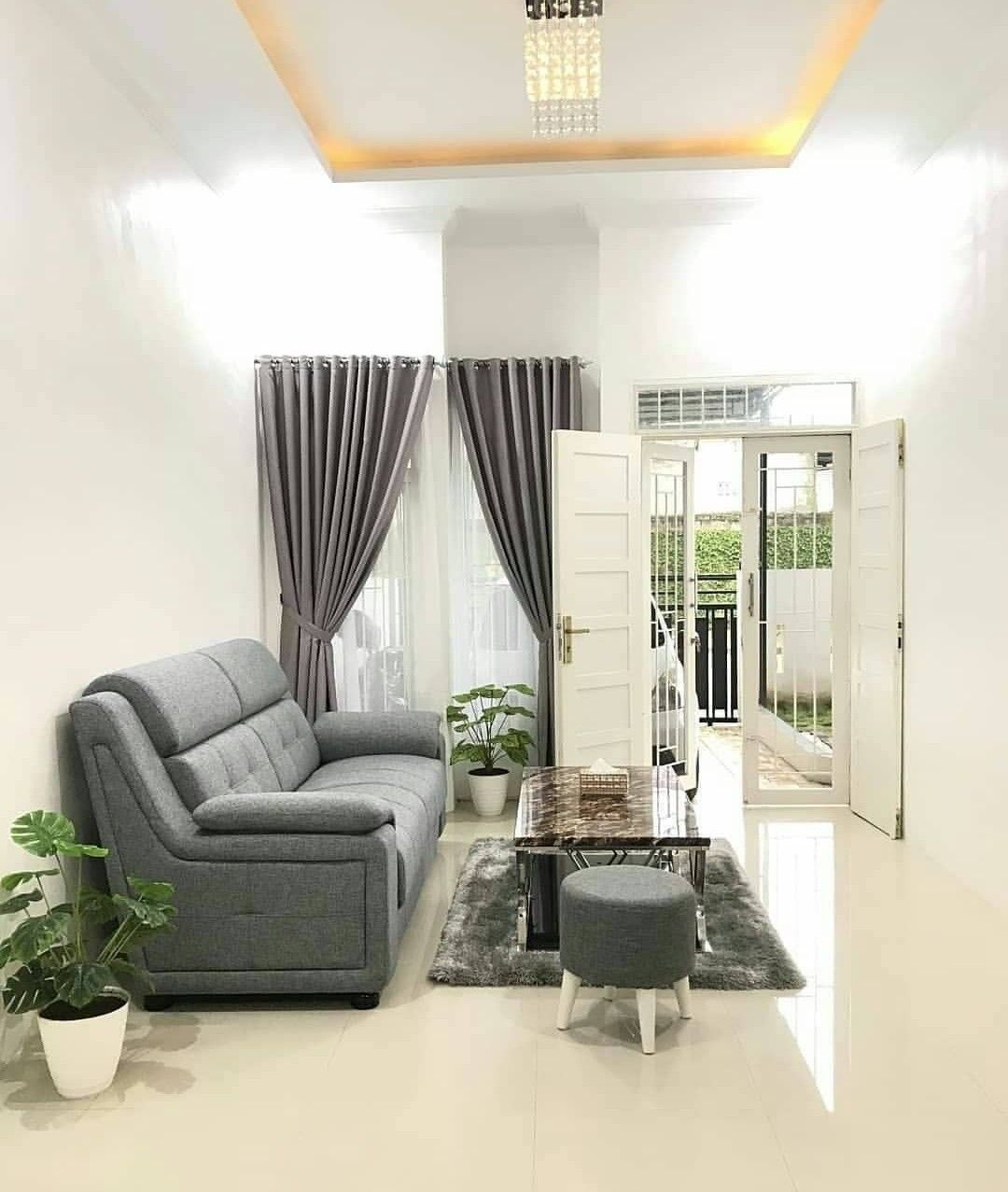 Dinding dan dekorasi didominasi warna putih untuk ilusi ruang luas di rumah minimalis type 36.