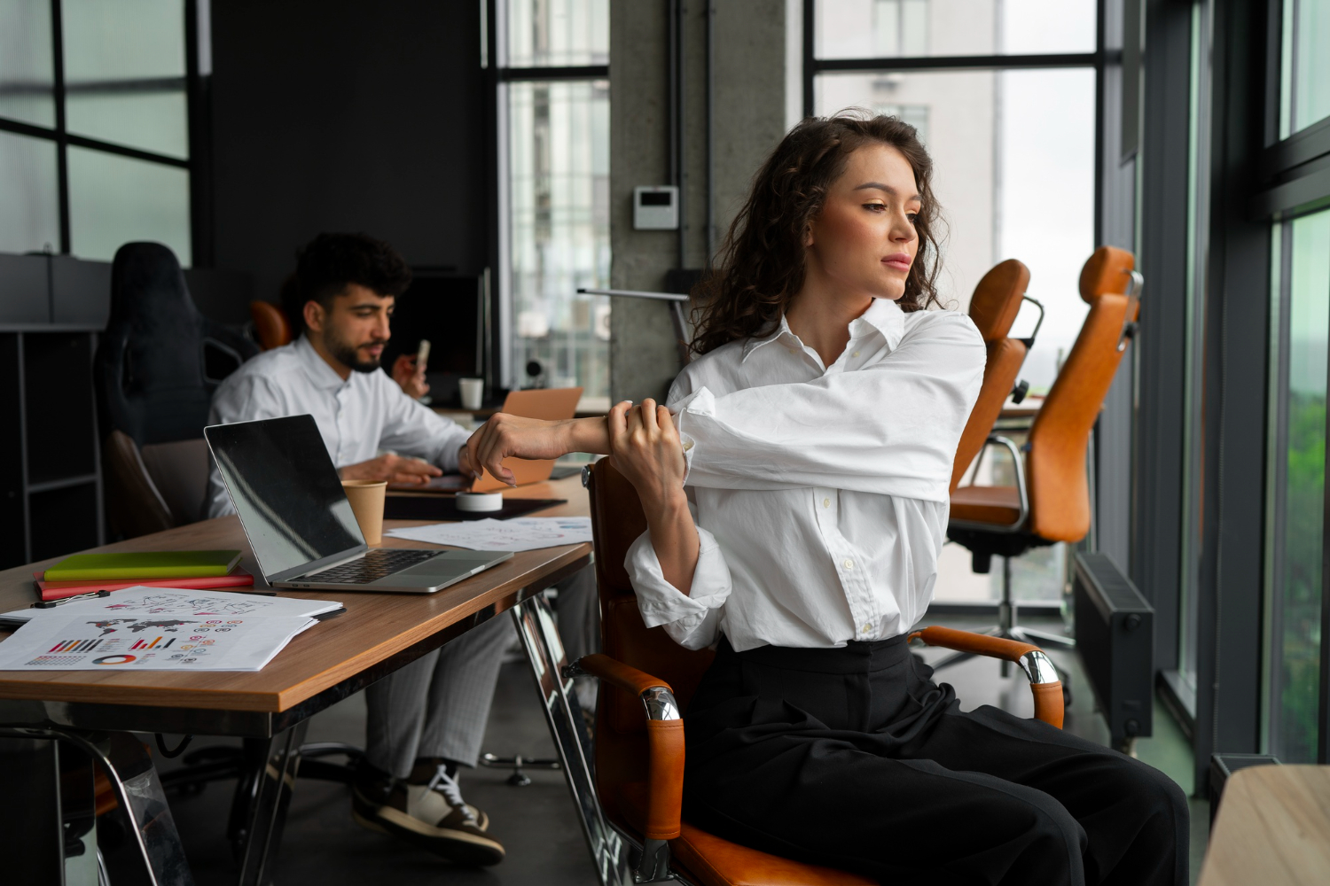 A person sitting with correct posture in an adjustable ergonomic chair, demonstrating good physical ergonomics.