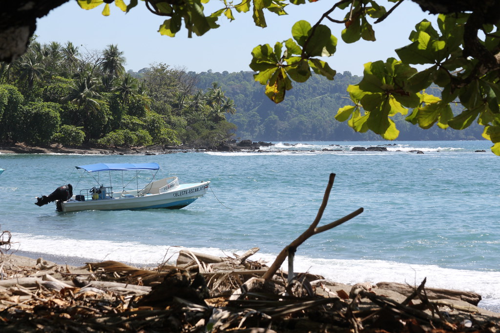 Cano Island with a beach and a ship in the foreground.