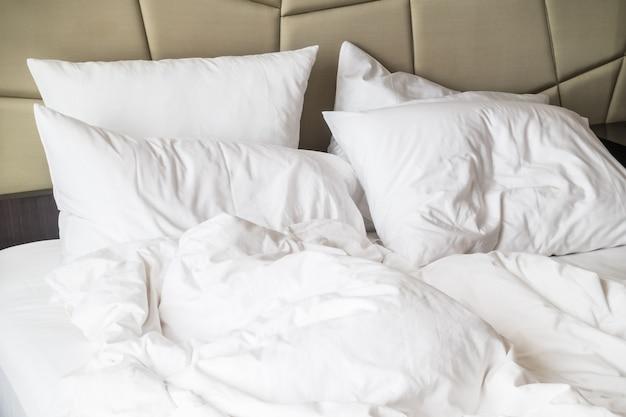 A bed with white pillows and a white blanket

Description automatically generated