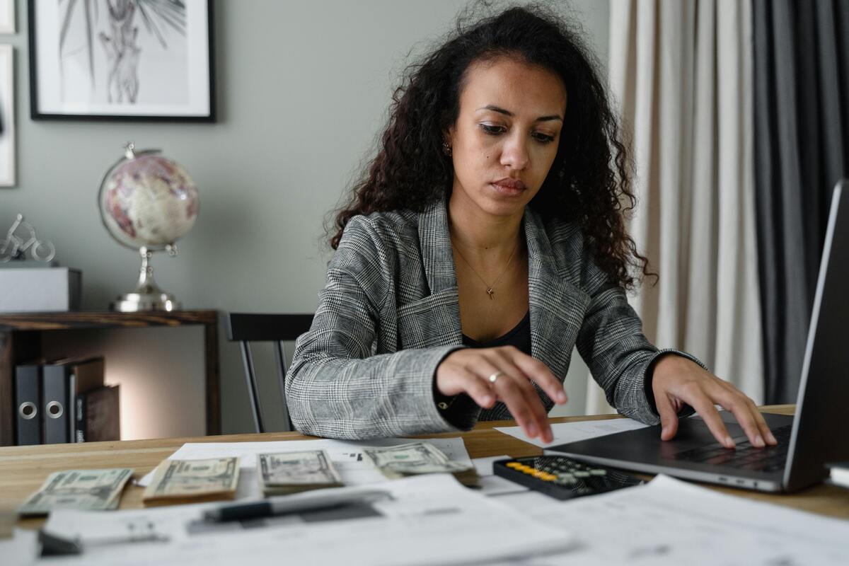 A woman using a laptop and calculator