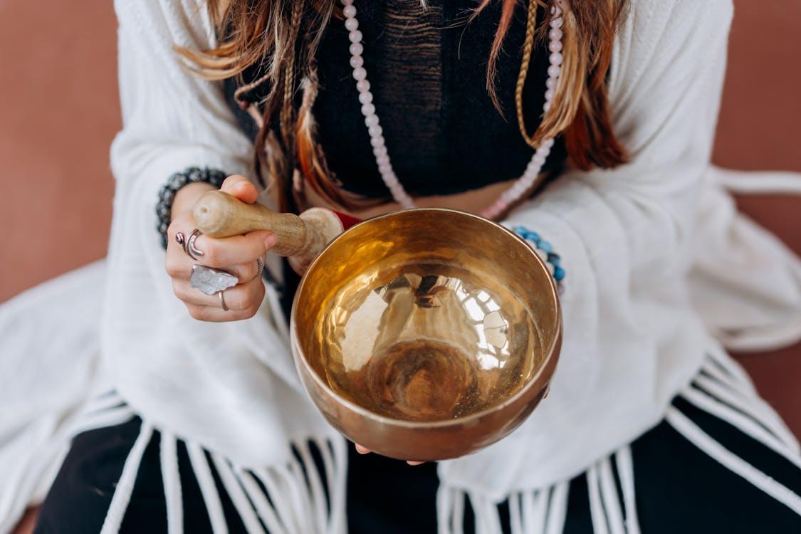 Free A woman holding a singing bowl, engaging in a peaceful meditation practice. Stock Photo