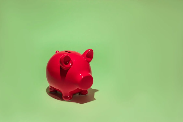 Red piggy bank on a green background, symbolizing savings, financial growth, and smart money management.