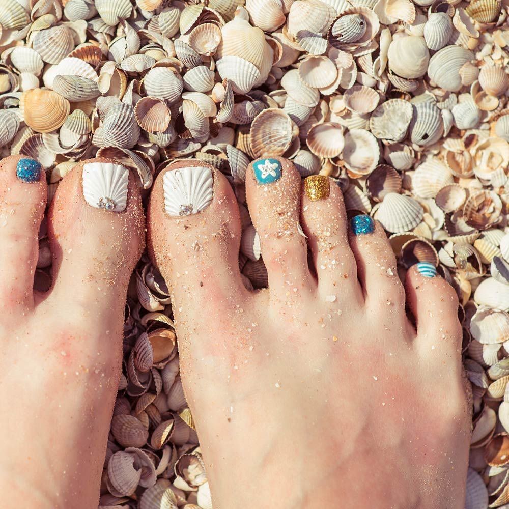 Close-up of toes sea shells giving ocean chill vibes