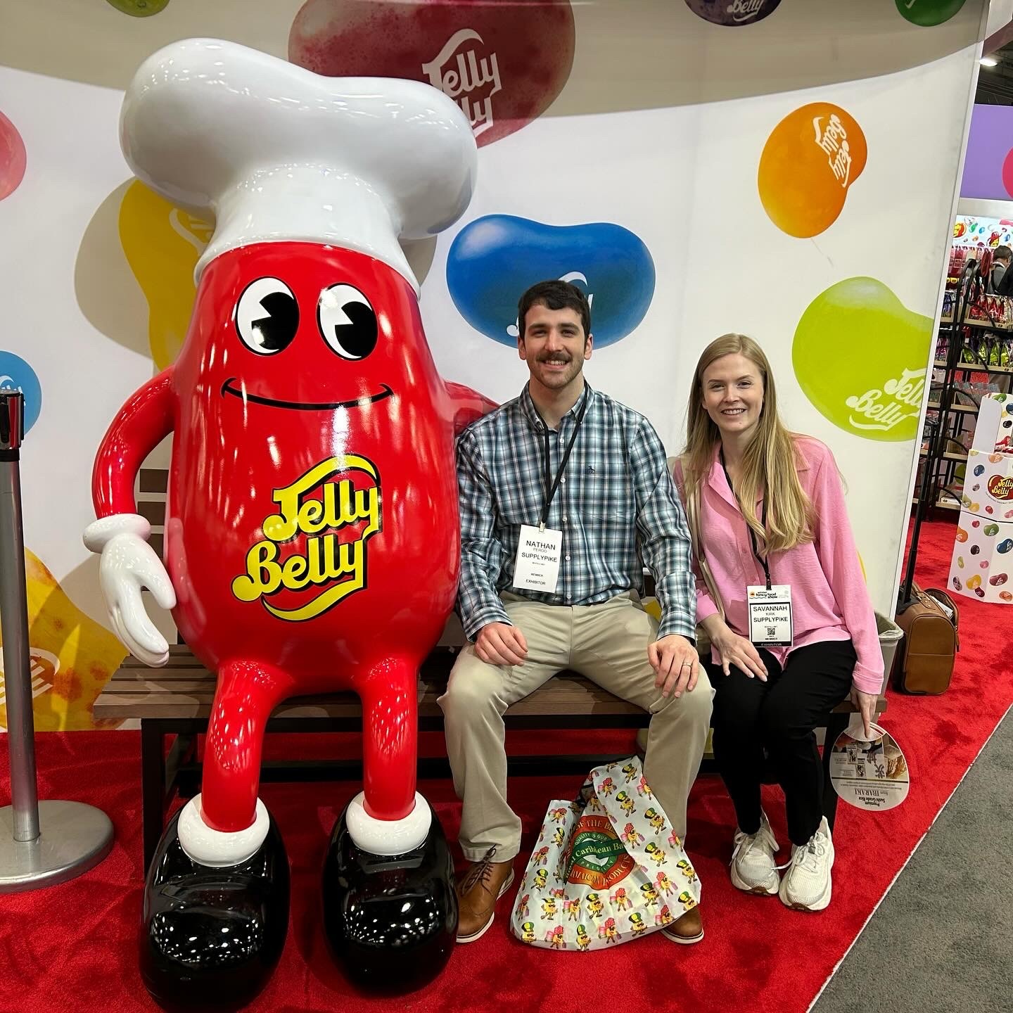 An image of SupplyPike's sales team, Nate and Savannah, sitting with a Jelly Belly mascot